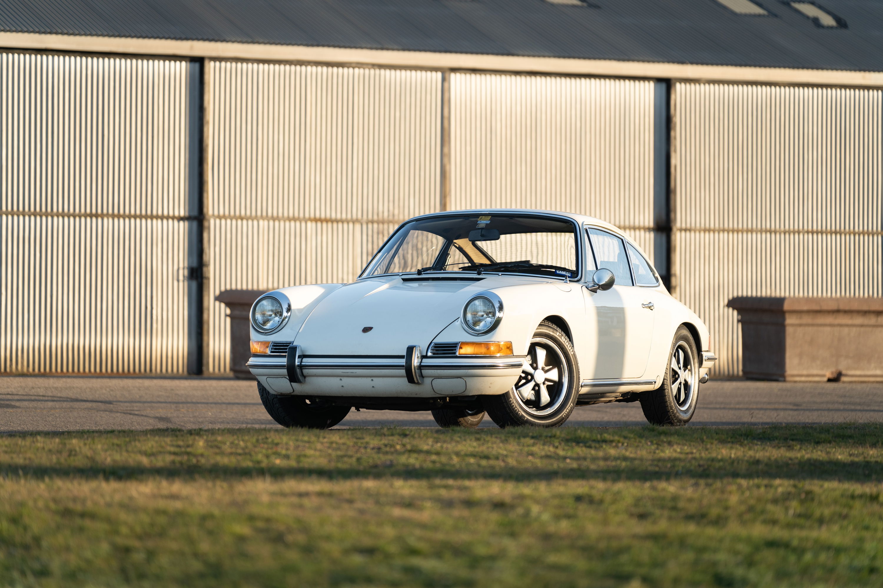 1970 Porsche 911T coupe in Light Ivory with chrome trim and Fuchs wheels.